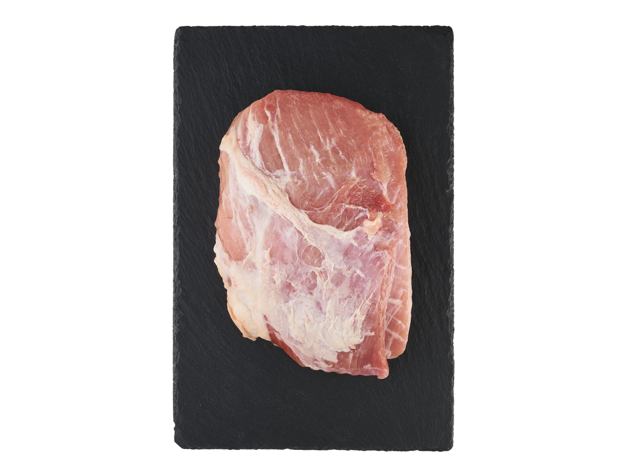 Šviežias kiaulienos kumpis ant juodos skalūno lentelės.
