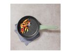 Frying pan with a light green handle, filled with colorful vegetables, on a grey background.