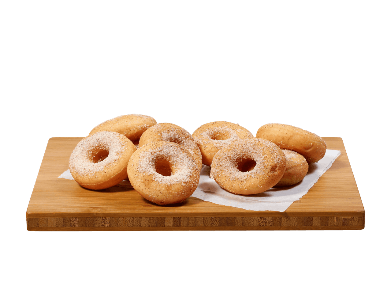 Ciambelle ricoperte di zucchero e cannella su un tagliere di legno.