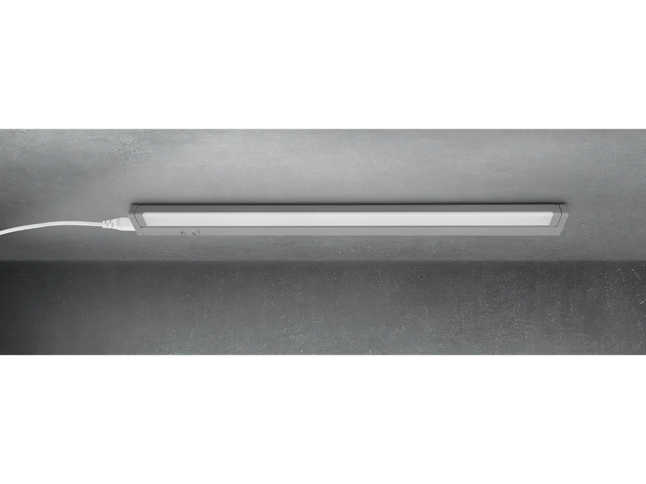 A slim, modern LED light fixture mounted on a concrete ceiling.