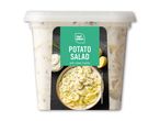 Kartoffelsalat med creme fraiche i en gennemsigtig beholder.