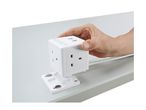 Hand holding a white cube-shaped power strip with multiple outlets and USB ports.