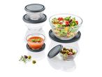 Glass storage bowls with gray lids, filled with salad, olives, and tomato soup.