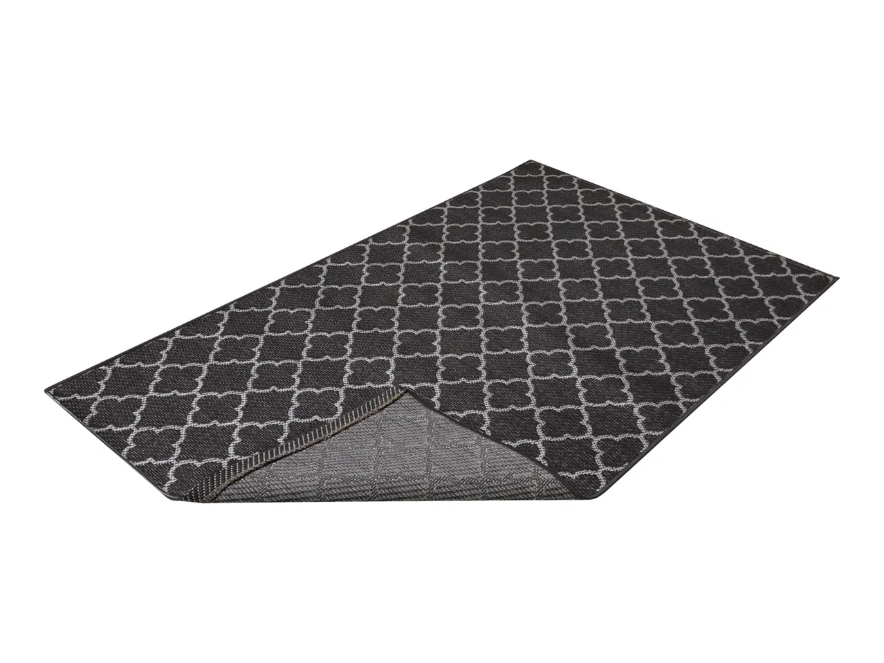 Dark grey patterned rug with a white geometric design, partially folded to show the underside.