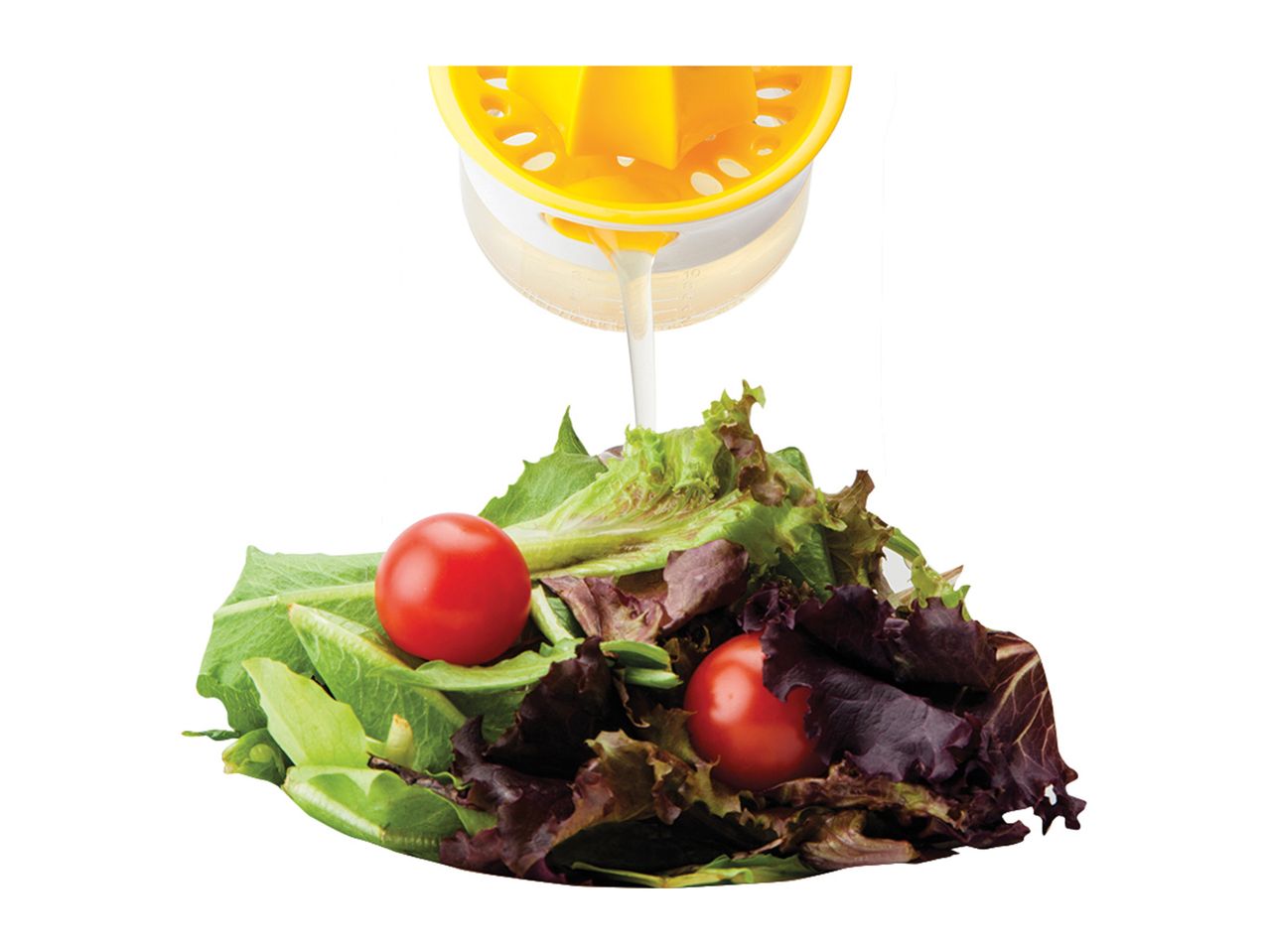 A citrus-shaped salad dressing server sits atop a small salad.