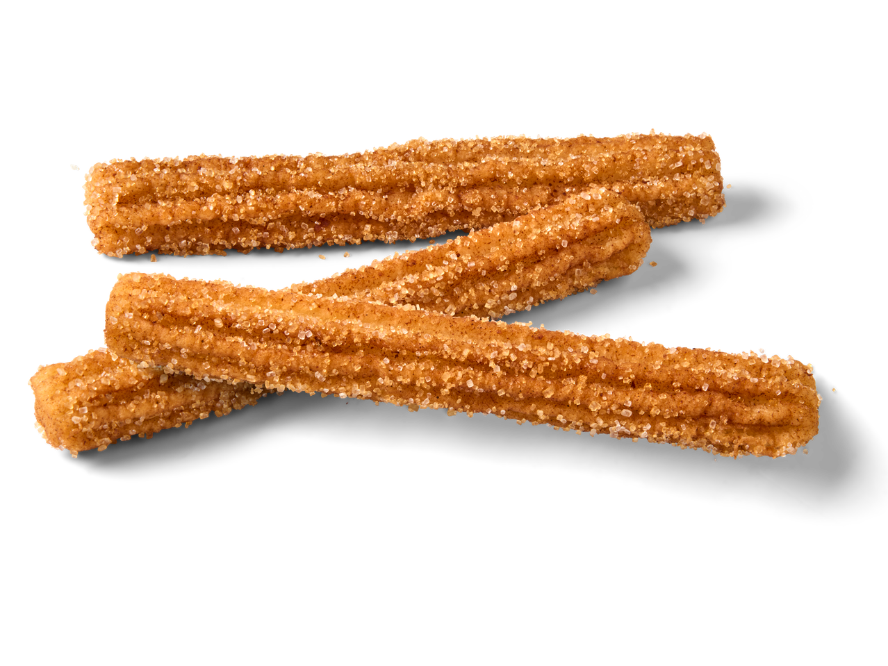 Drie churros met kaneel en suiker op een zwarte achtergrond.