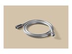Silver flexible shower hose coiled on a beige background.
