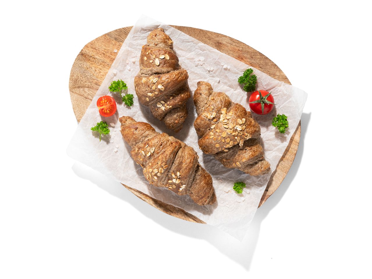 Zabpelyhes teljes kiőrlésű croissant fa táblán.