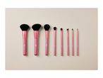 A set of eight pink-handled makeup brushes.