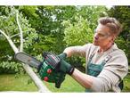 A man uses a Parkside chainsaw to cut a tree branch.