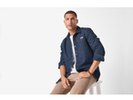 esmara® Men's Denim Shirt in dark blue, worn over a white t-shirt with beige trousers.