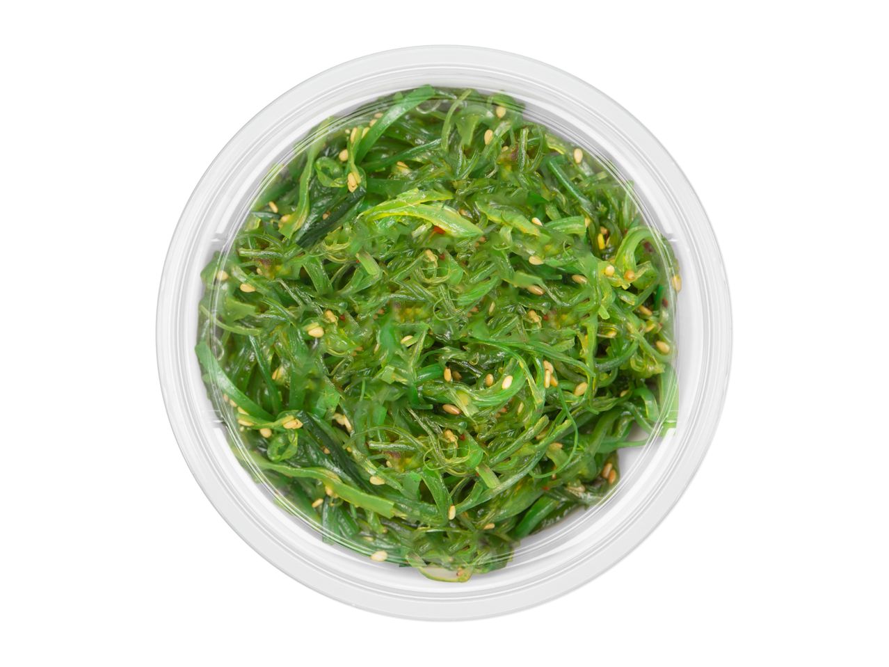 Overhead view of a clear plastic container filled with vibrant green seaweed salad, sprinkled with sesame seeds.