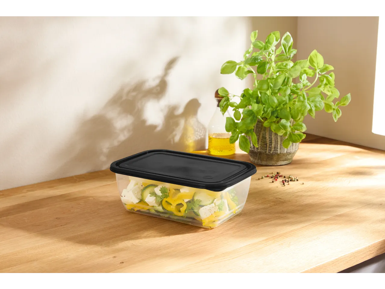 SILVERCREST® Food Storage Container with salad, oil, and basil on a wooden counter.
