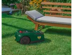 Gardena robotic lawnmower on green grass near a garden lounger.