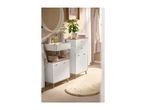Bathroom with white vanity units, a sink, mirror, plant, and a round rug on the floor.