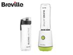 A personal blender with a white base and green trim, alongside a clear portable bottle.