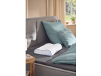 Livarno TopCool Neck Support Pillow on a bed with blue bedding and pillows.