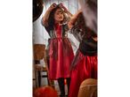 A young girl in a black and red bat costume with bat ears and face paint.