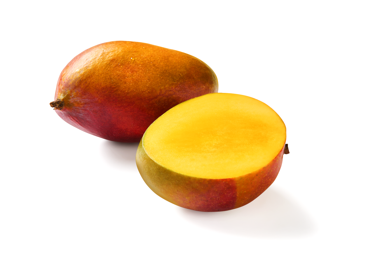 Eine ganze Mango und eine Mango-Hälfte liegen auf weißem Hintergrund.