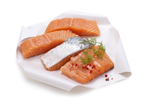 Tranches et filets de saumon sur papier sulfurisé.
