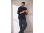 Man in donkerblauwe esmara Men® pyjama met lange mouwen en een broek met patroon.