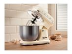 Cream-colored stand mixer with a stainless steel bowl on a wooden kitchen countertop