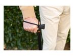 Close-up of an elderly person's hand holding a walking stick with a wrist strap.