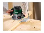 Person using a plunge router to cut a groove in a wooden board.