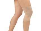 A person's legs with a beige knee brace on one knee.