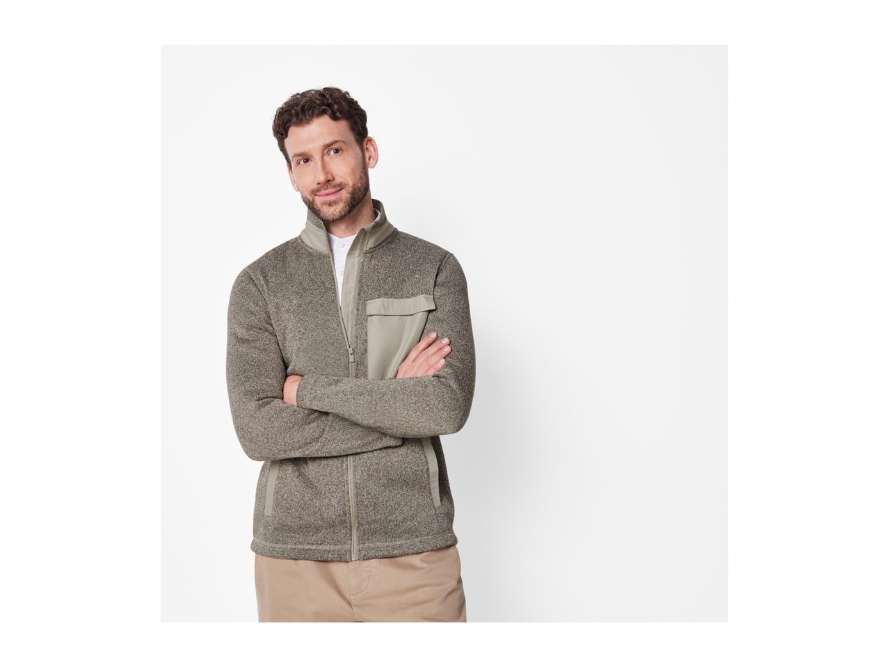 A man in a gray full-zip fleece jacket with a chest pocket and khaki pants.