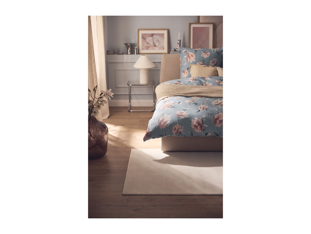Bedroom with floral duvet cover, beige throw, and decorative elements.
