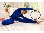 CRIVIT Ladies' Joggers in blue, worn by a woman stretching with a pilates ring.
