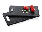 Two black cutting boards with cherry tomatoes and chopped spring onions