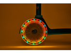 Lupilu Tri-Scooter with a spinning LED wheel, casting colorful light on a brown background.