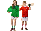 Two children in sports gear, a girl in green holding a Gaelic football and a boy in red with a hurley.