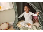 Happy child in Lupilu Kids' Pyjamas with pink hearts, sitting in a play tent.