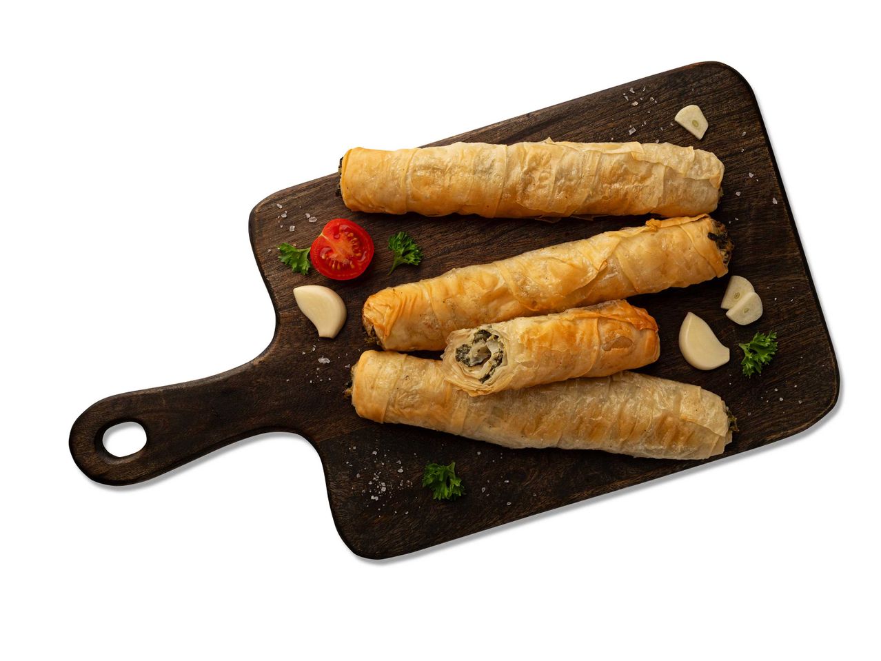 Spenótos és fetás burek tekercsek vágódeszkán, fokhagymával és paradicsommal.
