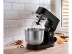 Black SILVERCREST® stand mixer with a stainless steel bowl, whisk, almonds, and eggs.