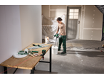 Woman mixing paint with a PARKSIDE® mixer, with a PARKSIDE® Cross Line Laser on a table.