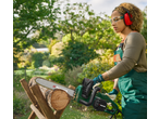 Woman cutting wood with a chainsaw, wearing safety glasses and ear protection.