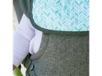 A baby in a carrier with a green and white chevron pattern.
