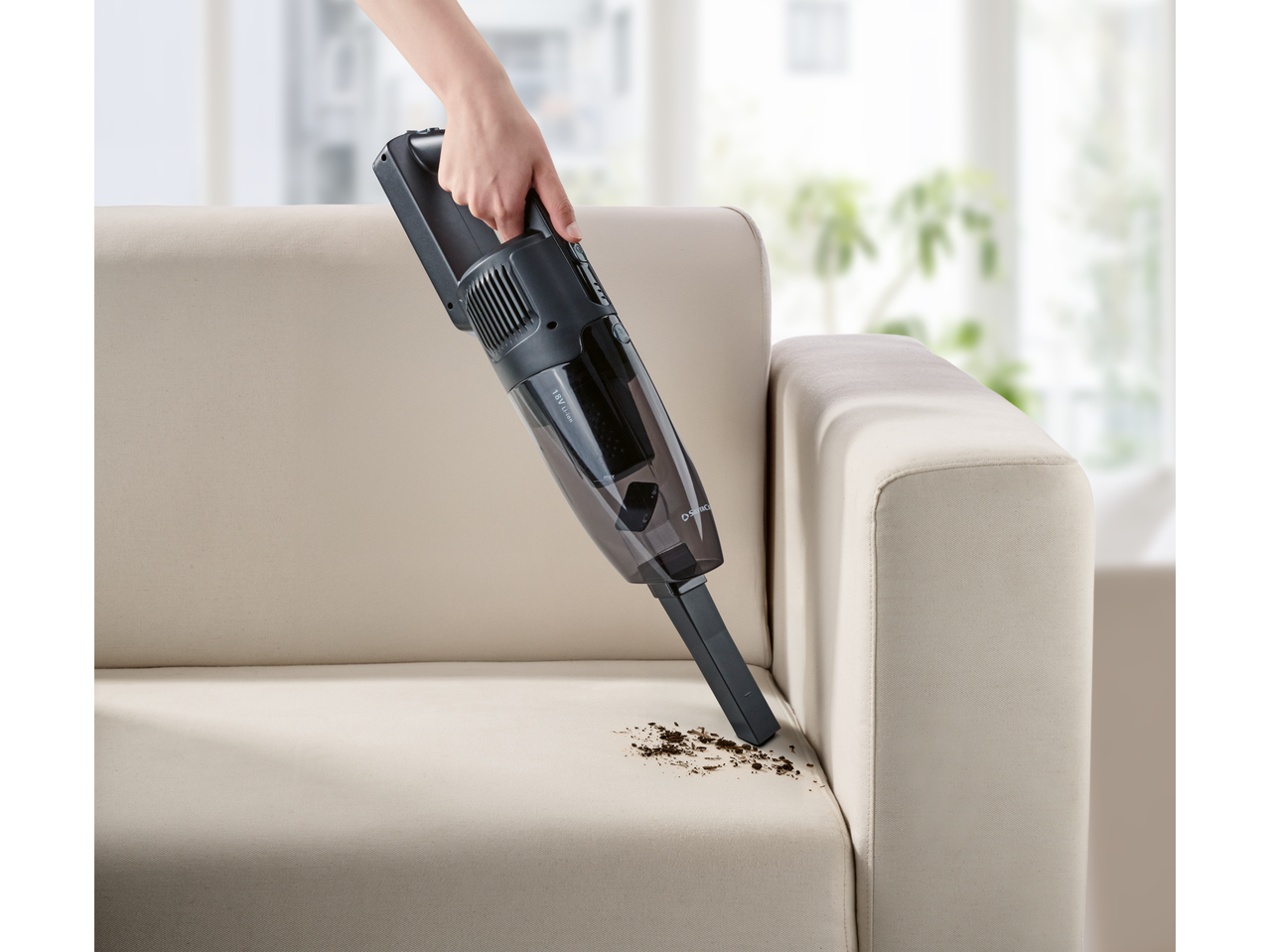 Silvercrest „2 u 1“ bežični usisivač čisti prljavštinu sa sofe.