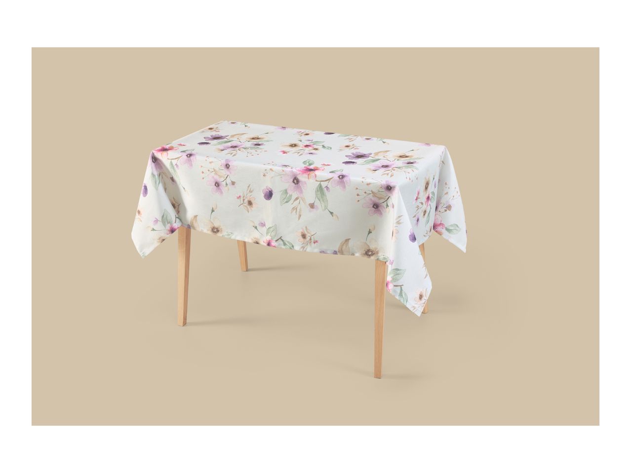 Floral tablecloth with pink and purple flowers draped over a wooden table.