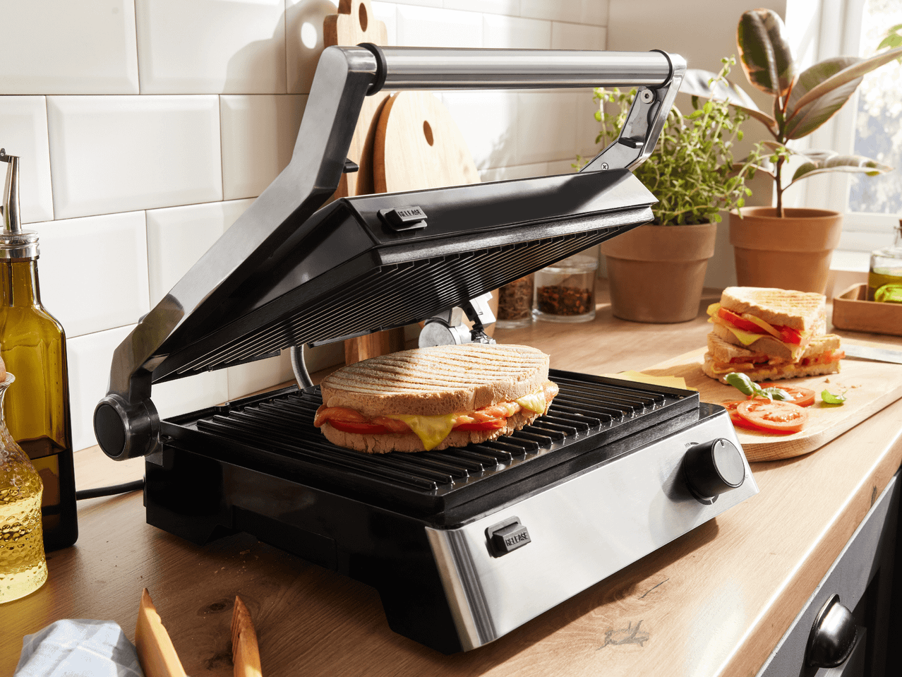 Ein Sandwichmaker mit einem Sandwich auf einer Holztheke in einer Küche.