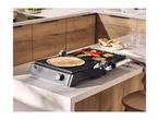 Electric grill with vegetables and tortilla on a kitchen counter