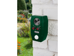 Green animal repeller with solar panel, mounted on a white wall in the garden.
