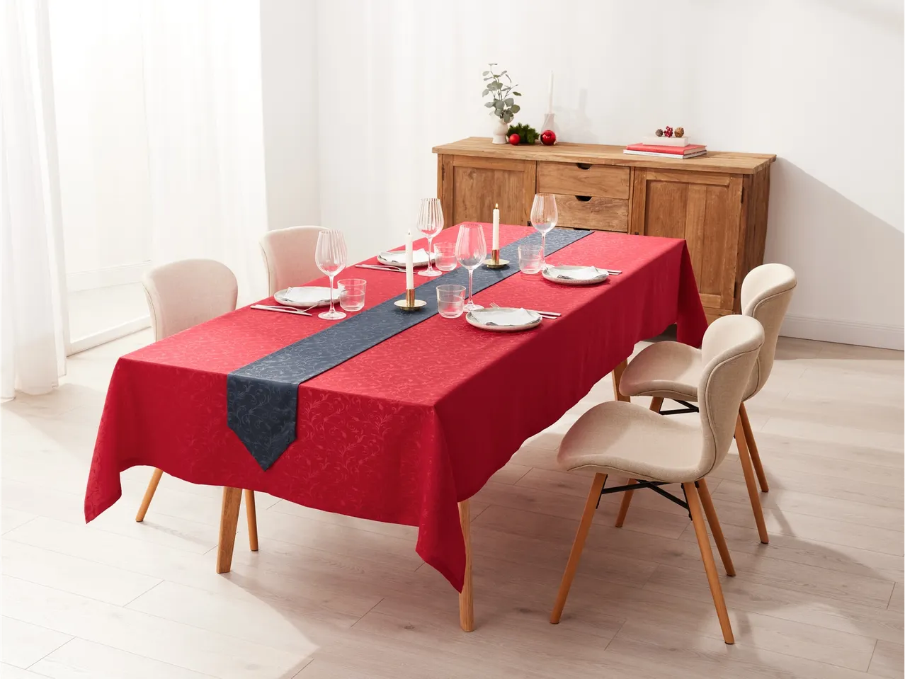 LIVARNO home galdautu komplekts ar sarkanu galdautu un tumši zilu galda celiņu uz ēdamgalda.