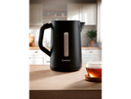 A black Silvercrest electric kettle sits on a wooden counter next to a cup of tea.