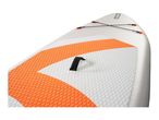 Close-up of a white and orange paddleboard with a textured deck pad and bungee cords.