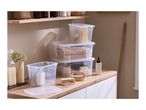 Clear storage boxes with lids, containing towels and cleaning supplies, on a wooden countertop.